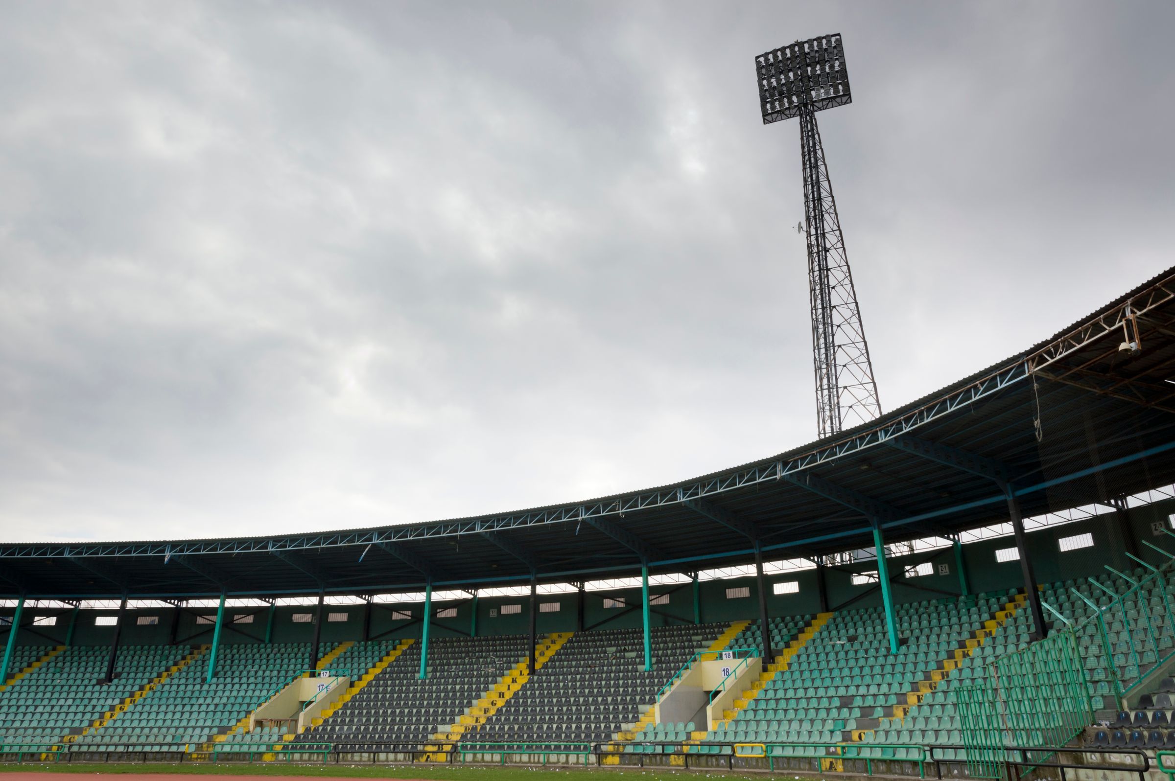 Empty football stadium under a cloudy match-day sky